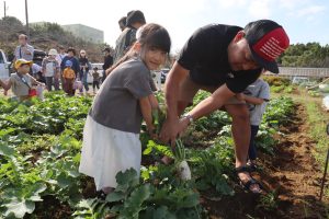 抱えているのは「足早の秋」の恵み。農業公園で秋の収穫祭